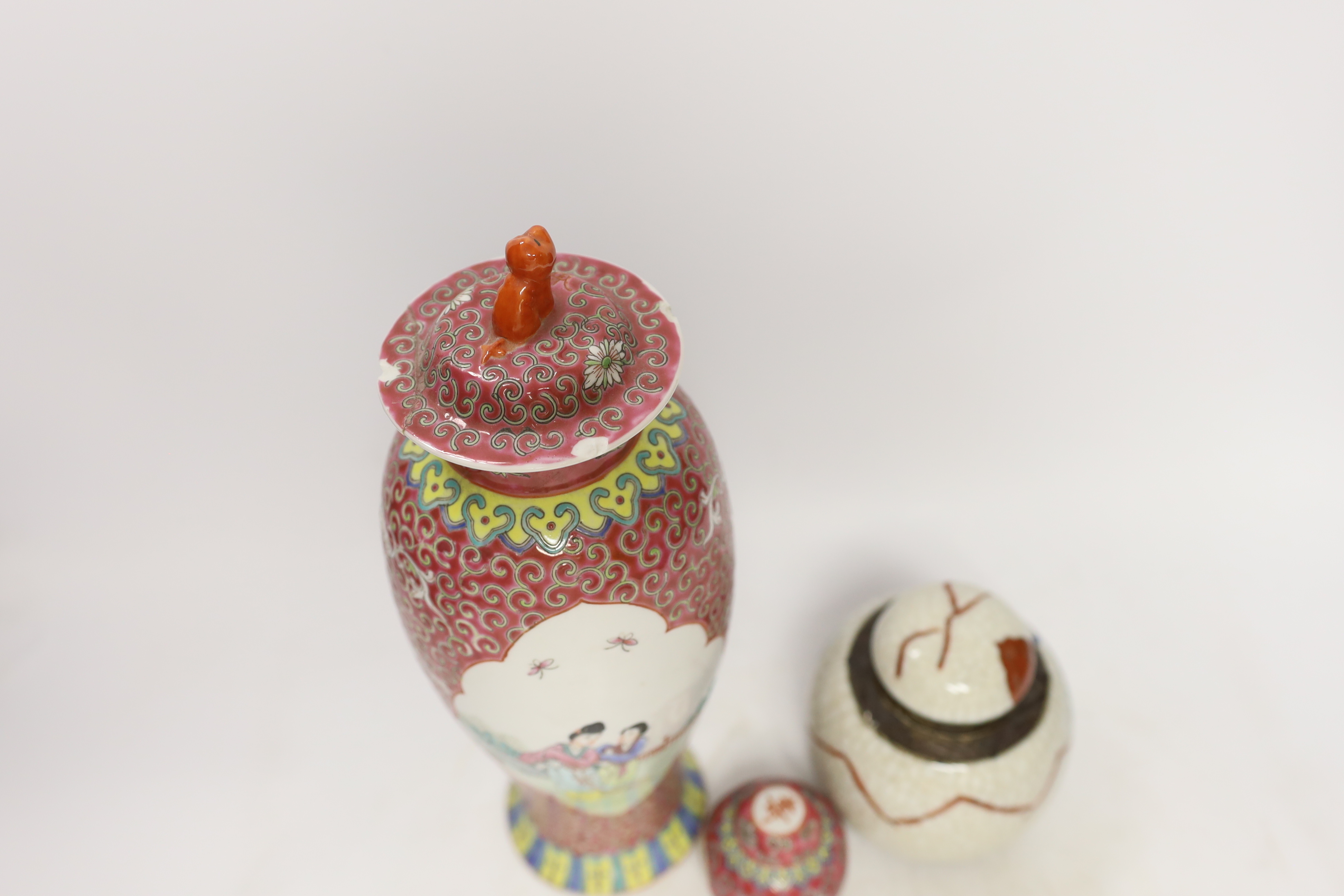 An early 20th century Chinese famille rose vase and cover, similar small jar and cover and a famille verte crackleglaze jar and cover, tallest 31cm